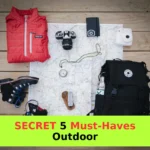 black hiking backpack near white Fujifilm instax mini camera near black leather boots, red half-zip jacket, gray pocket watch on white map